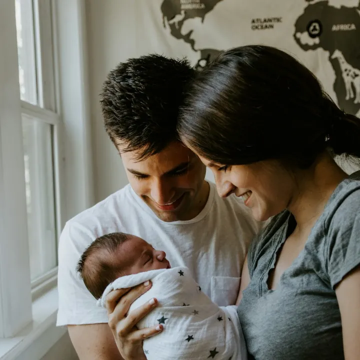 New parents smiling down at their newborn